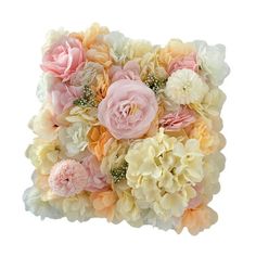 a bouquet of pink and white flowers on top of a square shaped pillow with greenery