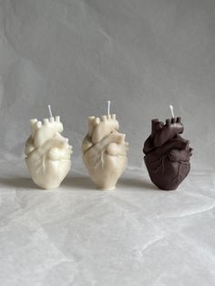 three heart shaped candles sitting next to each other