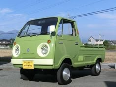 a small green truck parked in a parking lot