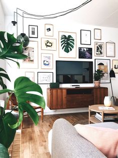 a living room filled with furniture and pictures on the wall behind a flat screen tv