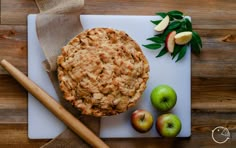 an apple pie sitting on top of a cutting board