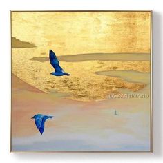 two blue birds flying over the ocean at sunset