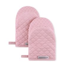 two pink oven mitts sitting next to each other