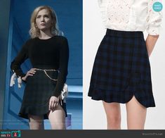 the young woman is wearing a black and white plaid skirt