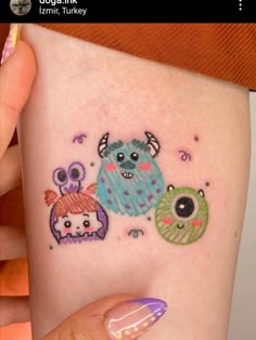 a woman's thigh with three little monsters on it