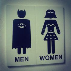 two bathroom signs depicting men and women dressed as batman and batgirl, on the wall