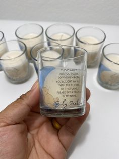 a person holding a small glass filled with candles