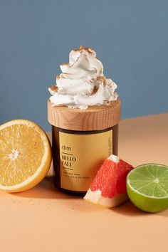 a jar of whipped cream next to sliced oranges, lime and watermelon