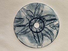 a black and white drawing of flowers on a cd