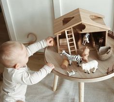 a baby playing with toys on a wooden table