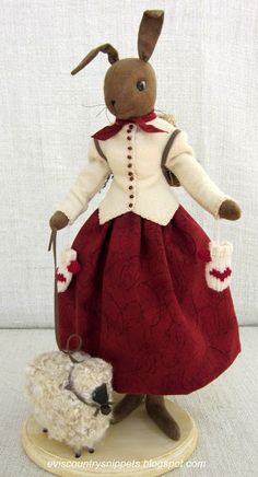 a stuffed animal is dressed in a red dress and holding a white sheep's head