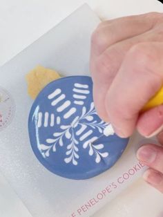 a person is decorating a cookie with icing