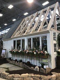 a house made out of wood and windows with flowers in the window boxes on each side