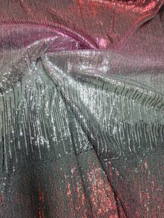 the fabric is shiny and has red, silver and black sequins on it