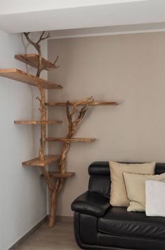 a living room with a black leather couch and wooden shelves