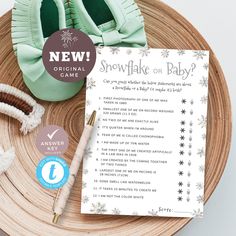 a snowflake baby shower game is shown on a wooden tray with its contents