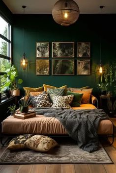 a bedroom with dark green walls and wooden flooring is furnished with an overstuffed bed