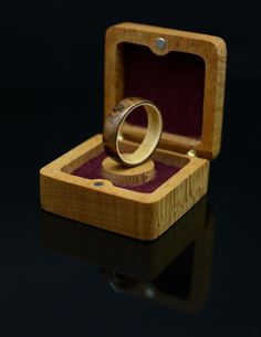 a wooden box with a wedding ring in it