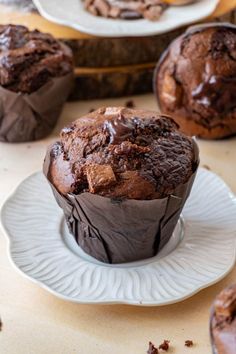 chocolate muffins sitting on top of white plates