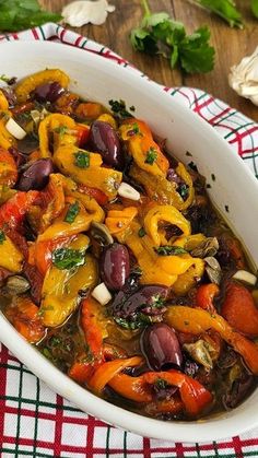 a white dish filled with vegetables on top of a table