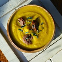 a yellow bowl filled with food on top of a wooden table