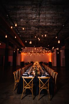 a long table is set up with black linens and gold chairs for an event