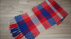 a red, white and blue blanket laying on top of a wooden floor