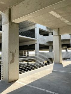 an empty parking lot with concrete pillars and balconies