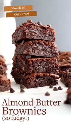 chocolate brownies stacked on top of each other next to a glass of milk with the words, flourless oil free almond butter brownies