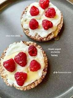 two desserts with raspberries and cream on them are sitting on a plate