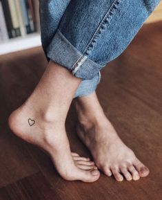 a person's foot with a small heart tattoo on their left ankle and the word interest written in red ink