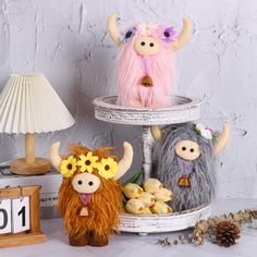 three stuffed animals sitting on top of a table next to a lamp and other decorations