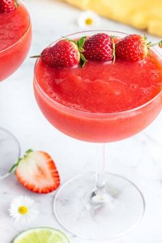 two glasses filled with strawberry margaritas and garnished with strawberries