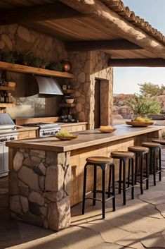 an outdoor kitchen with stone counter tops and bar stools next to the grill area