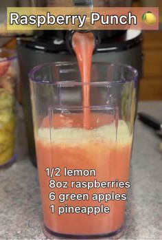 a blender filled with orange juice on top of a counter