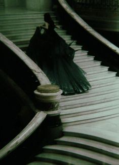 an umbrella is sitting on the edge of a set of metal steps in front of a building