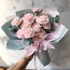 a bouquet of pink carnations and greenery