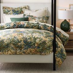 a bed with a floral comforter and pillows