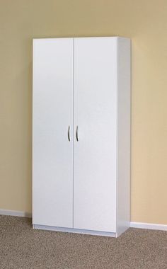 a tall white cabinet sitting in the corner of a room next to a carpeted floor