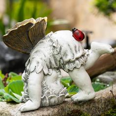 a white statue with a ladybug on it's head