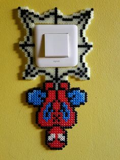 a light switch cover with an image of a spiderman hanging on it's side