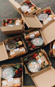 several boxes filled with different types of food on top of the ground next to each other