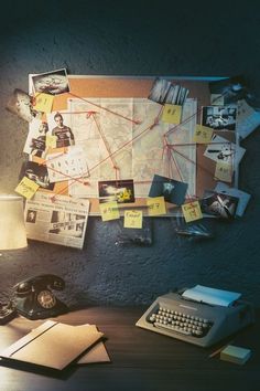 an old typewriter sitting on top of a desk next to a lamp and pictures