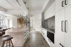 a kitchen with marble counter tops and white cabinets, along with an island in the middle