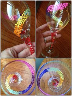 a hand holding a wine glass filled with colorful beads