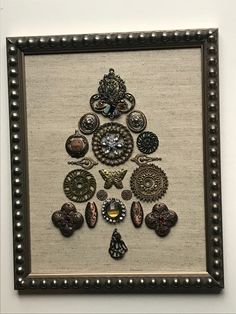 an art piece with buttons and other items on it in a frame hanging on the wall