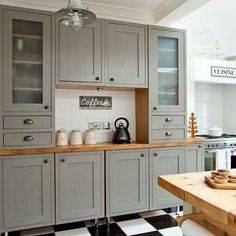 a kitchen with gray cabinets and black and white checkered flooring on the walls