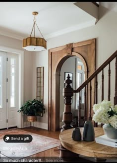 an entry way with flowers and vases on the table