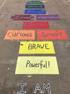 several different colored signs on the ground with words written below them that read i am curious, brave, i am curious