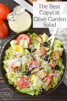 a salad with tomatoes, lettuce, olives and parmesan cheese